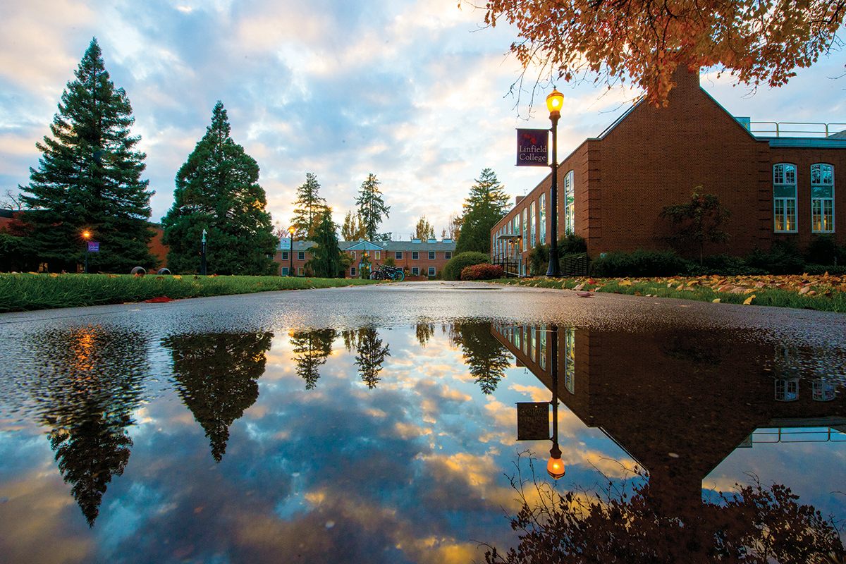 Sunset reflected in a sidewalk puddle.