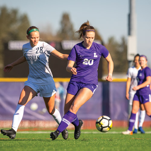 LInfield women's soccer player dribbling ball on the new turf