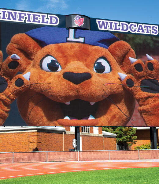 Mack the Wildcat pictured on the video display and standing next to it, to illustrate the size.