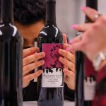 students labeling a wine bottle
