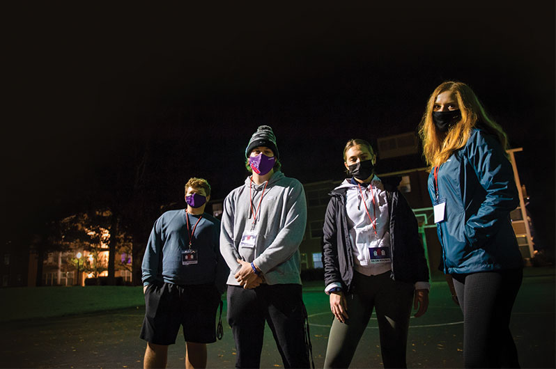 Four resident advisors standing outside at night about to go on their rounds throughout the south side of campus: Samuel Dixon '24, Evan Bates '22, Carmel Wolff '23 and Kelsey Jordan '23.