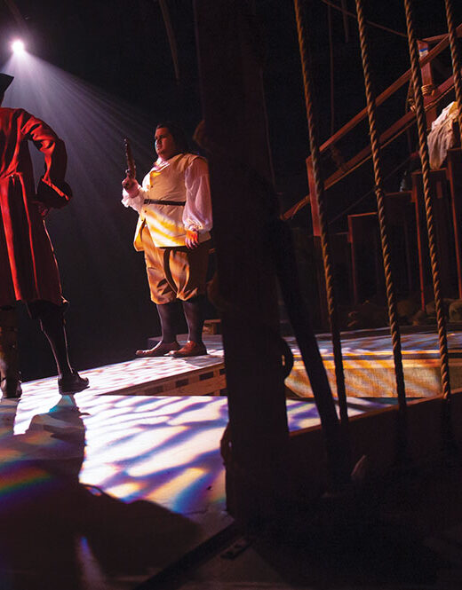 Student actors on stage performing a scene from Treasure Island