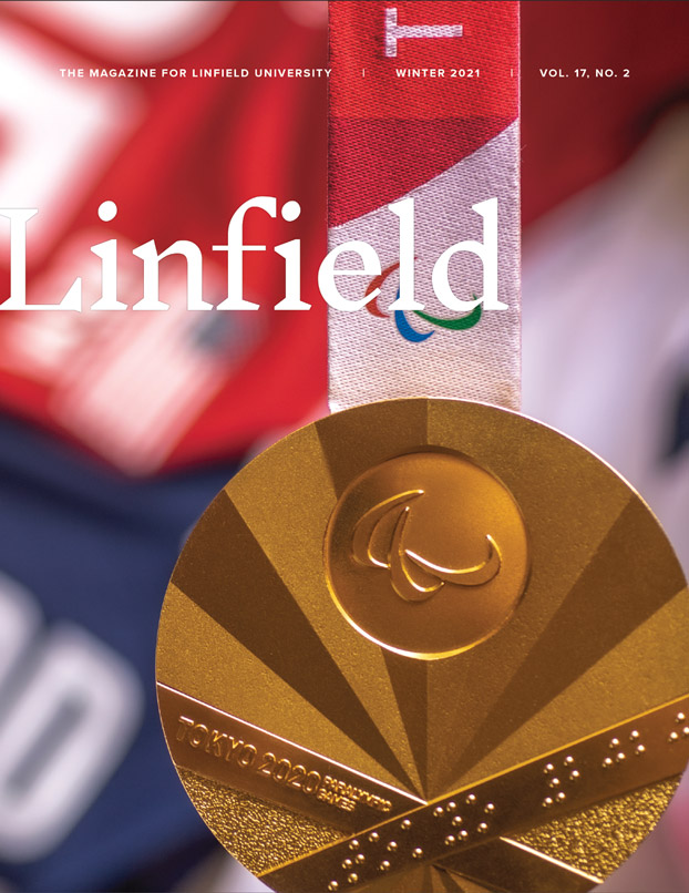 Linfield Magazine winter 2022 cover: Olympic gold medal with Annie Flood's Olympic jersey in the background