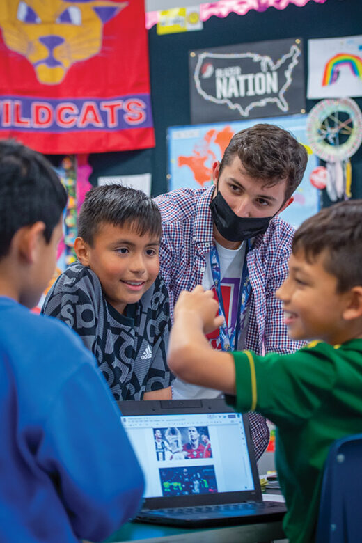 Rylee in the classroom with three students