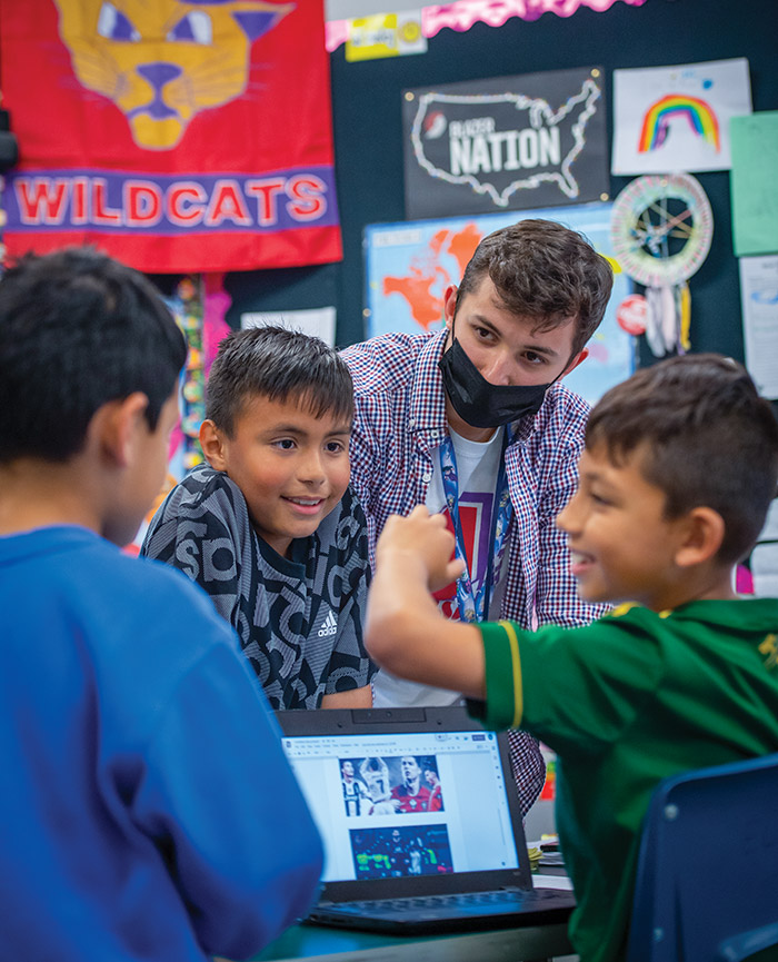 Rylee in the classroom with three students