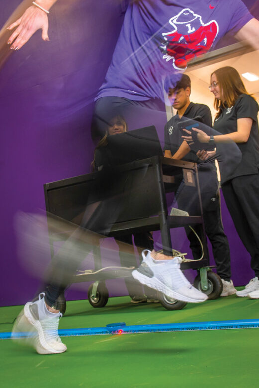 Linfield graduate students measuring an athlete's speed.
