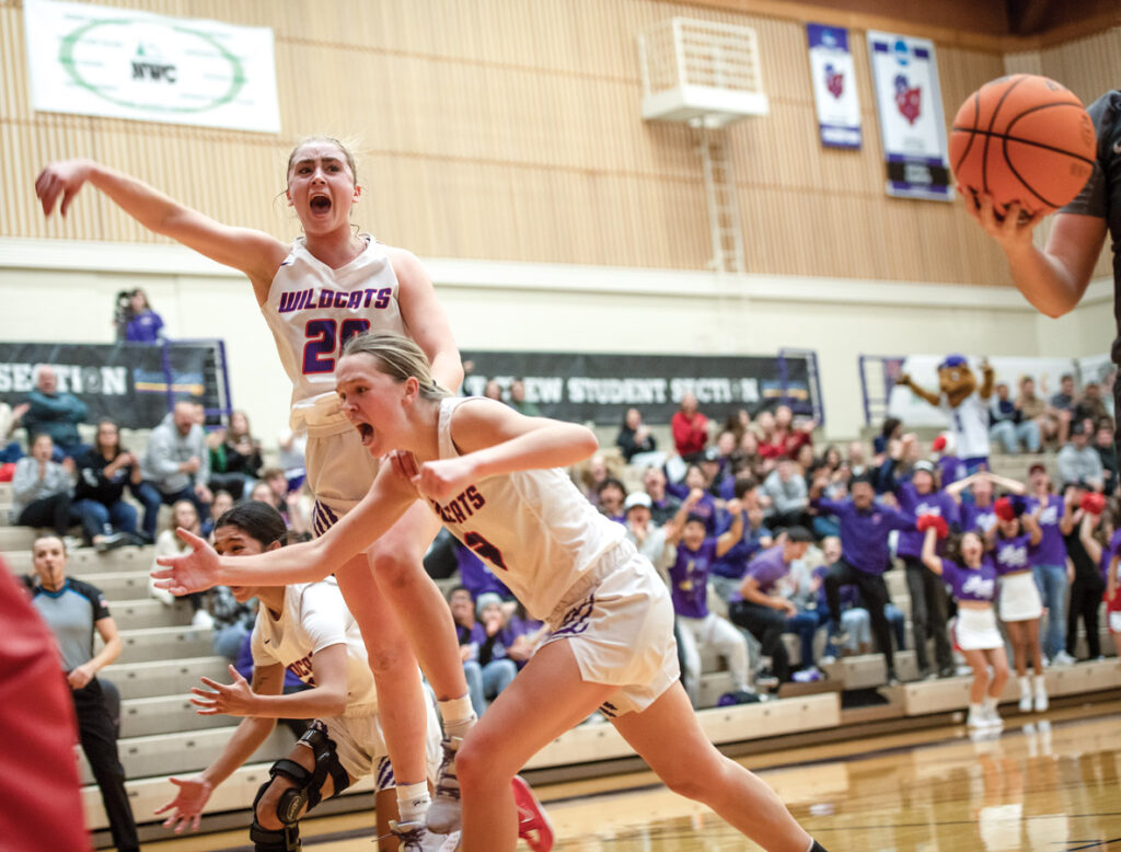 Two Wildcat women's basketball players celebrating on the court.
