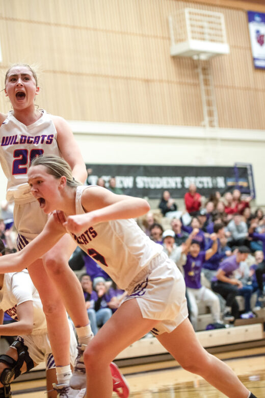 Two Wildcat women's basketball players celebrating on the court.