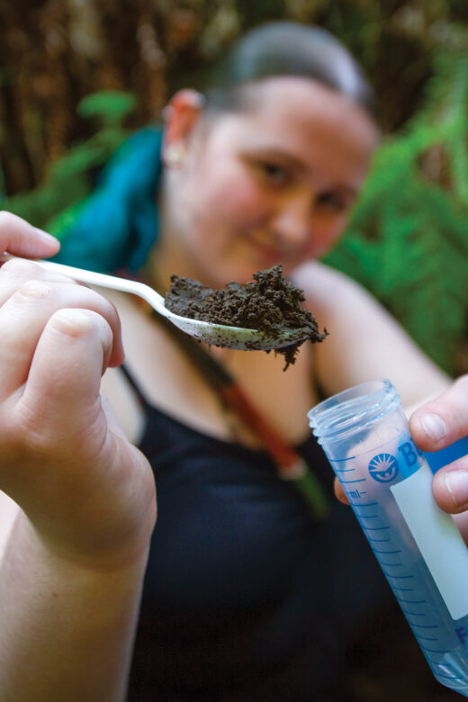 Student holding plastic spoon full of dirt.