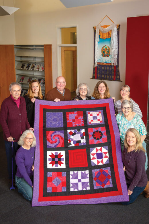 Thirteen quilters with Vivian Bull's original quilt.
