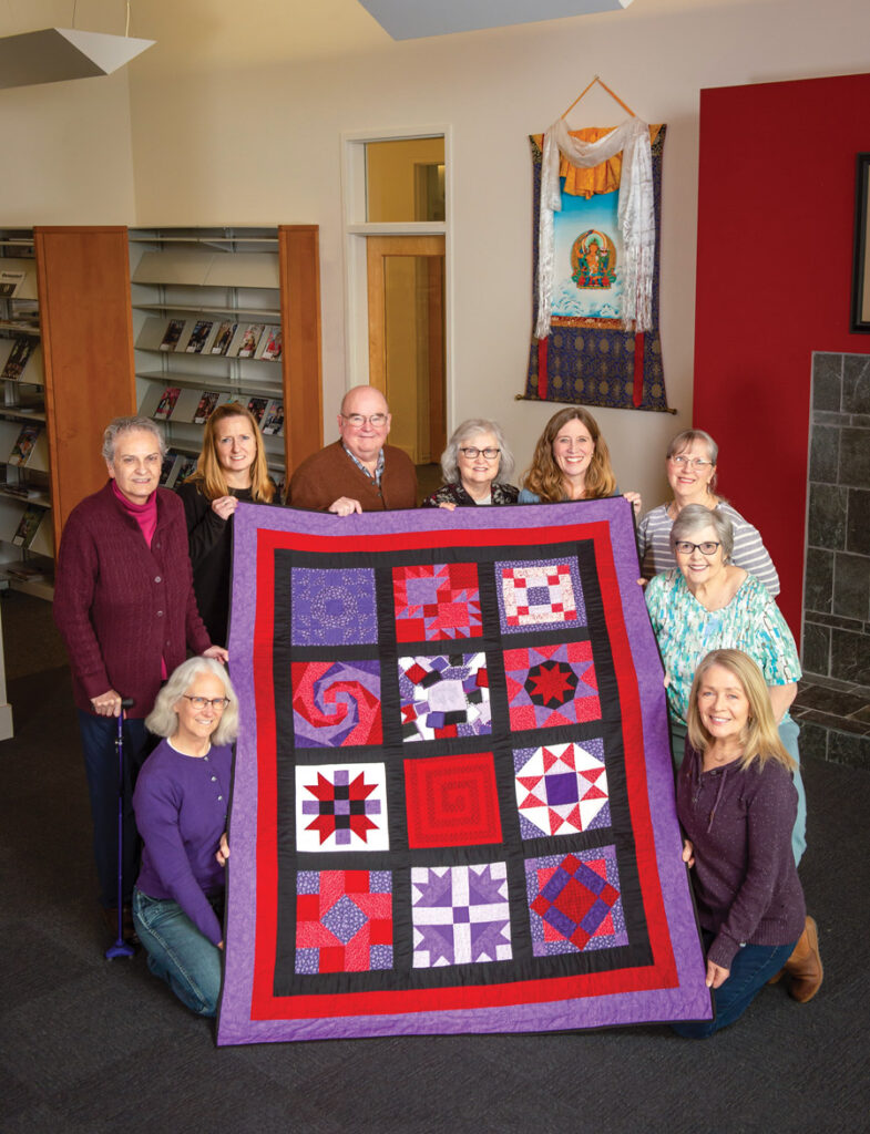Thirteen quilters with Vivian Bull's original quilt.