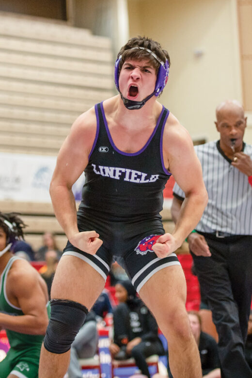 Male student wrestler celebrating a win.