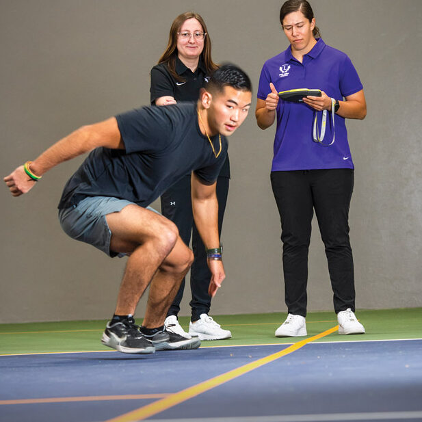 Two Linfield graduate students working with an athlete.