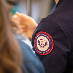 Linfield University School of Nursing patch on student scrubs.