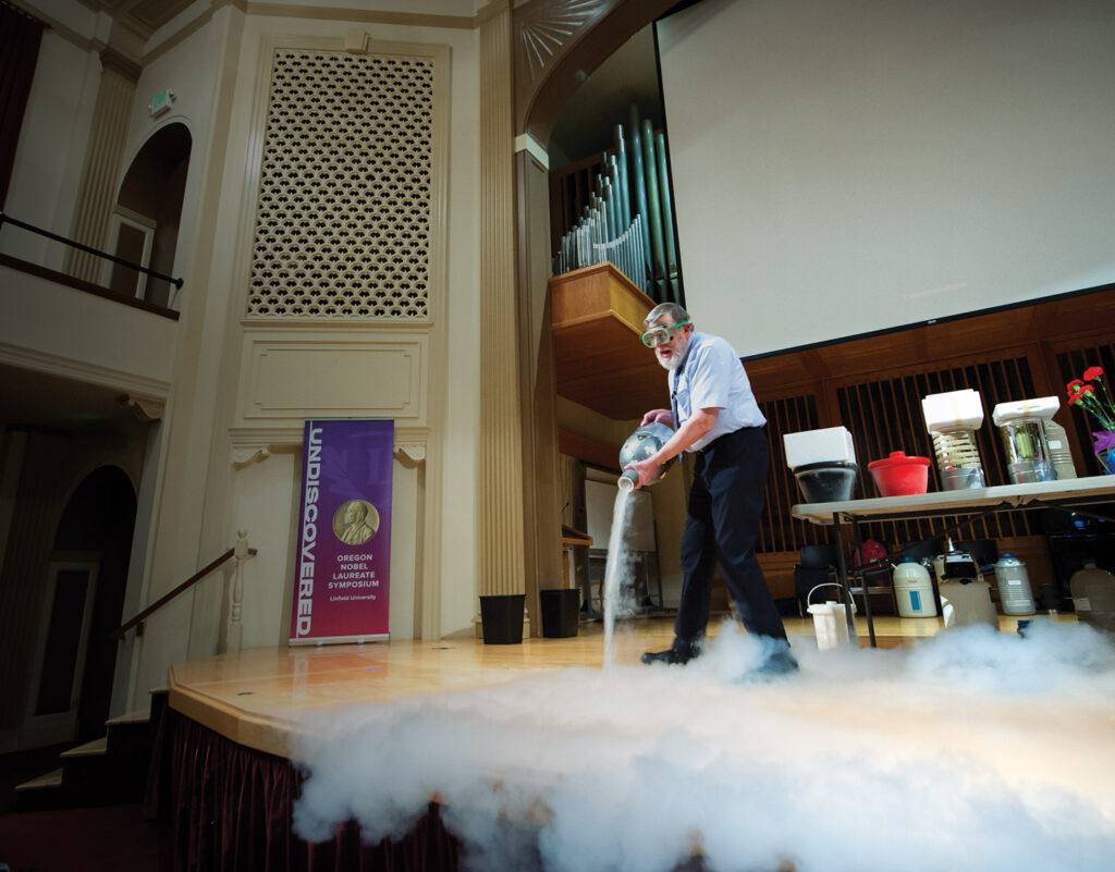 Nobel laureate Bill Phillips performing an experiment on stage.