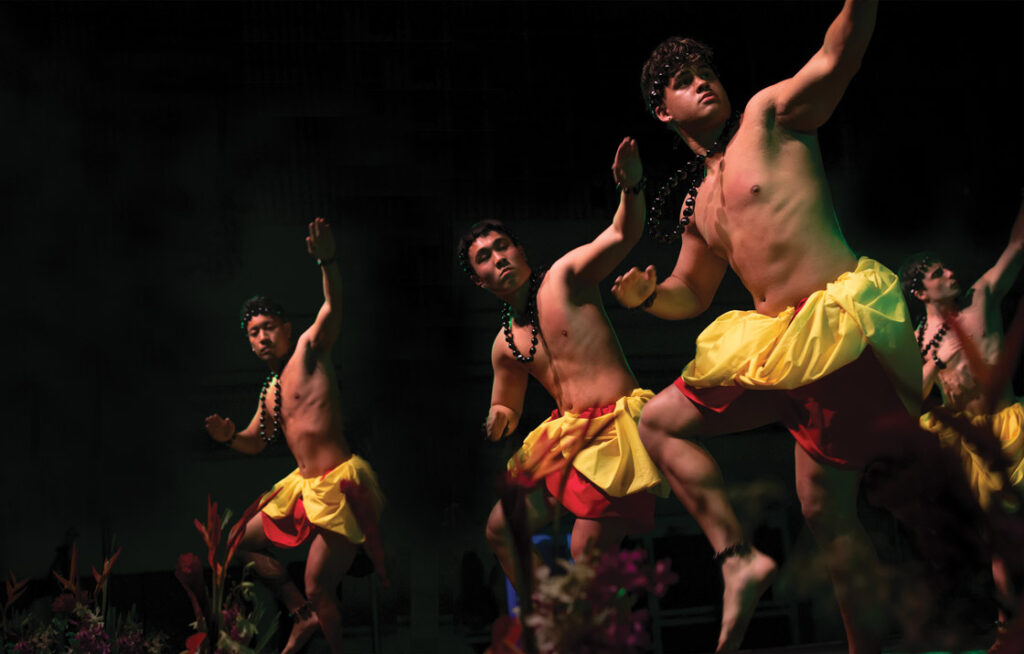 Three male Linfield students performing on stage ad the 50th annual lu'au and ho'ike.