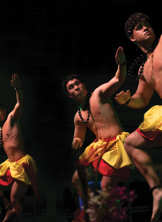 Three male Linfield students performing on stage ad the 50th annual lu'au and ho'ike.