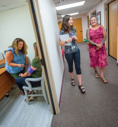 Two women walking down a hall in the Student Health, Wellness and Counseling Center.