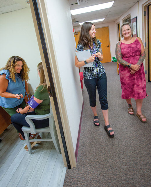 Two women walking down a hall in the Student Health, Wellness and Counseling Center.