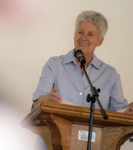 Interim President Becky Johnson speaking at a podium.