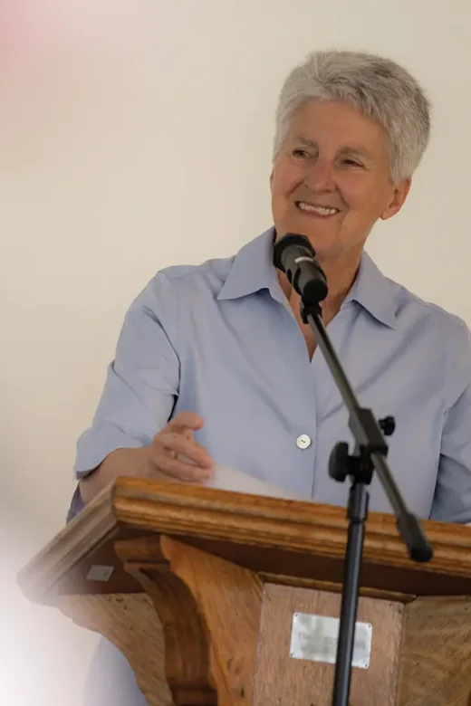 Interim President Becky Johnson speaking at a podium.