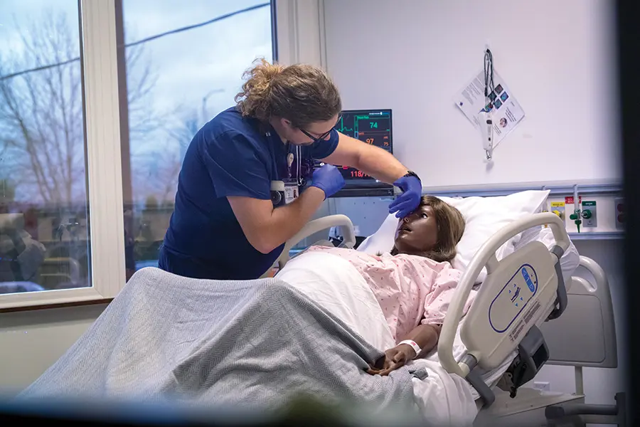 student performing a medical check on the manikin.