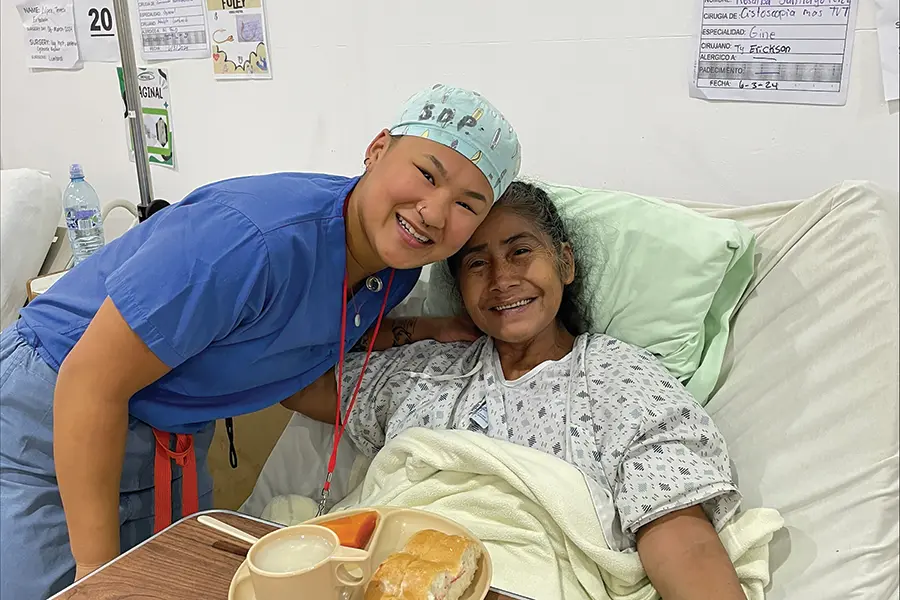 Alice Rickett takes a photo with a patient in a hospital bed in Guatemala.