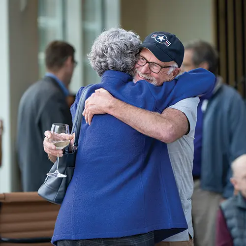 Two people hugging at a reunion.