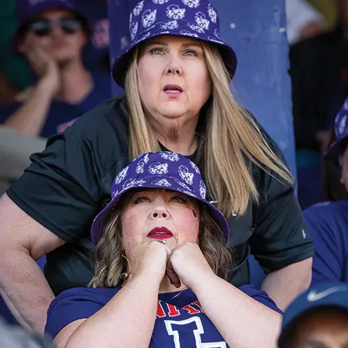 two people in the stadium watching the Homecoming football game.