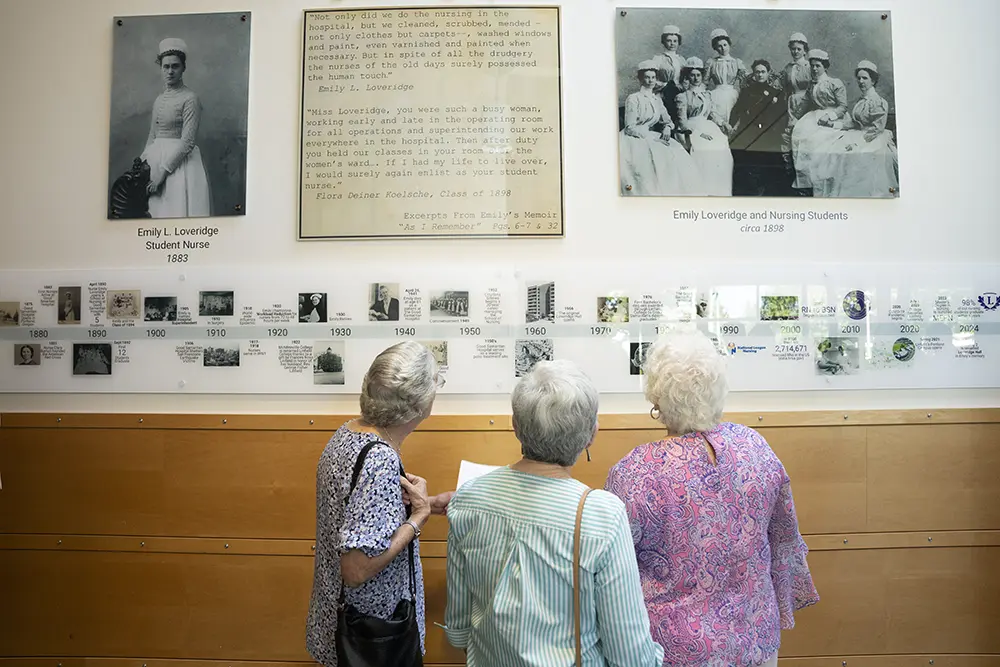 Three attendees viewing the exhibit.